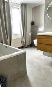 a bathroom with a tub and a sink and a window at WEINHOF Winningen Traumwohnung im „La Mosel• in Winningen
