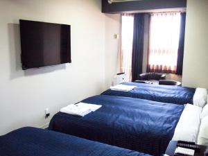 Łóżko lub łóżka w pokoju w obiekcie HOTEL LiVEMAX BUDGET Nagoya Taikodori