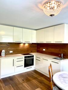 a kitchen with white cabinets and a chandelier at WEINHOF Winningen Traumwohnung im „La Mosel• in Winningen