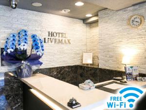 hol hotelowy z recepcją ozdobioną niebieskimi kwiatami w obiekcie HOTEL LiVEMAX BUDGET Nagoya Taikodori w mieście Nagoja