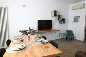 a dining room table with chairs and a television at Domus Silvana Apartments in Ravenna