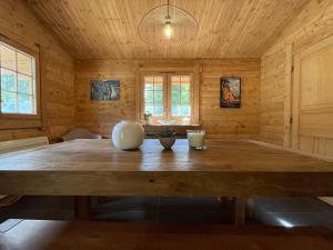 einen großen Holztisch in einem Zimmer mit Holzwänden in der Unterkunft Le Refuge de Belbriette, chalet au coeur de la nature avec spa in Xonrupt-Longemer