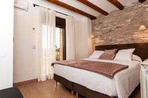 Casa Nicole في Portell: غرفة نوم بسرير كبير وجدار من الطوب