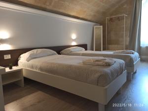 two beds in a hotel room with at In & Out Matera in Matera