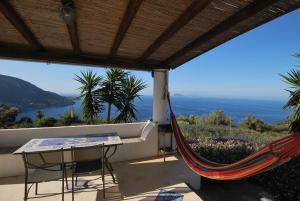a porch with a hammock and a view of the ocean at Atollo in Lipari