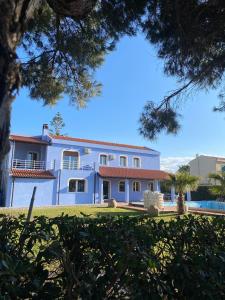 a large white house with trees in the foreground at Villa Maria Marchesana in Pezzi di Gala