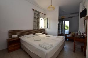 a bedroom with a large white bed in a room at Morpheas Rooms in Palaiochora