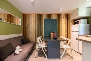 a living room with a couch and a table at Village Nature et Océan à côté de la plage avec piscine et jacuzzi in Messanges