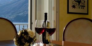 een tafel met twee wijnglazen en een fles wijn bij Ascona: Nostrana Apt. 2 in Ascona