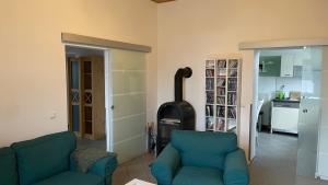 a living room with two blue chairs and a stove at Alte Post - Erdgeschoß in Gützkow
