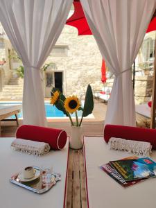 アラカティにあるViento Alacati Hotelのテーブル(赤い椅子2脚付)と白いカーテン