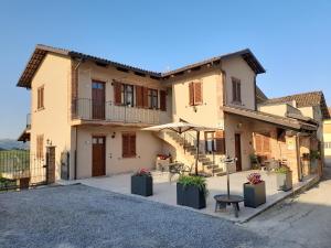 ein Haus mit einem Tisch und einer Bank davor in der Unterkunft Agriturismo I Grappoli in Serralunga d'Alba
