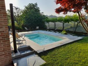a swimming pool in the backyard of a house at Agriturismo I Grappoli in Serralunga d'Alba