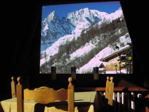 telewizor z widokiem na pokrytą śniegiem górę w obiekcie Hotel Astoria w mieście Courmayeur