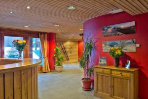 una stanza con pareti rosse e fiori in cima a armadi in legno di Résidence Néméa Le Nevez a Les Contamines-Montjoie Altre 33 foto