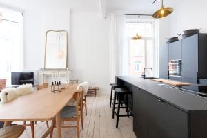 a kitchen with a wooden table and a counter top at Cosy and Modern 2 bedrooms flat near Châtelain and Brugmann in Brussels