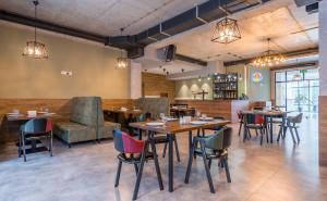 a restaurant with tables and chairs and a couch at Aura Hotel Tbilisi in Tbilisi City