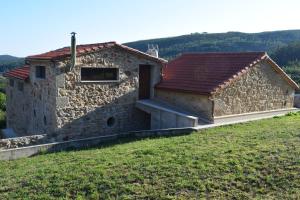 a stone house with a door on a hill at Casa Crego in Dumbría