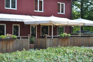 restauracja z białymi parasolami przed budynkiem w obiekcie Slagsta Motell & Wärdshus w mieście Norsborg