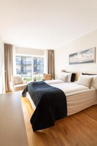 a white bedroom with a large bed and a couch at Lindesnes Havhotel in Spangereid