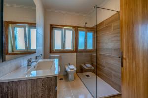 a bathroom with a sink and a toilet and a shower at Central Suites Arouca in Arouca +27 photos