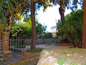 una recinzione in un parco con alberi e una panchina di Albergo Enrica a Roma