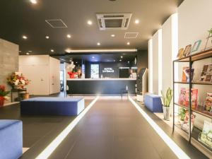 een lobby van een winkel met blauwe banken en een balie bij HOTEL LiVEMAX Aichi Toyota Ekimae in Toyota