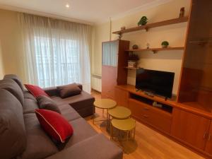 a living room with a couch and a flat screen tv at APARTAMENTO FUNCIONAL LALIN-CENTRO in Lalín