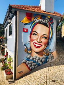 uma grande pintura de uma mulher ao lado de um edifício em dourobluehouse em Marco de Canavezes