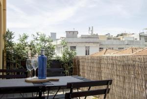una mesa con una botella y vasos en el balcón en LL Picaria 16, en Oporto