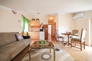 una sala de estar con un sofá y una mesa en Apartments Veronika, en Zadar