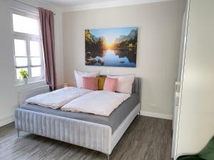 een slaapkamer met een bed met een schilderij aan de muur bij Ferienwohnungen Albarts by Mountain apart in Wernigerode