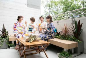three women in kimonos sitting on a balcony with drinks at trive sakae 最大7名宿泊可能 矢場町駅徒歩3分 栄 大須観音スグ in Nagoya