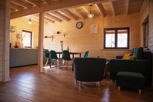 ein Wohnzimmer mit einem Tisch und grünen Stühlen in der Unterkunft Nowe Domki w Borsku z Balią kąpielową in Borsk