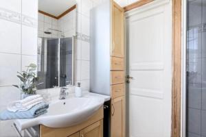 a white bathroom with a sink and a mirror at Lys og sentral leilighet med terrasse og hage in Lillehammer