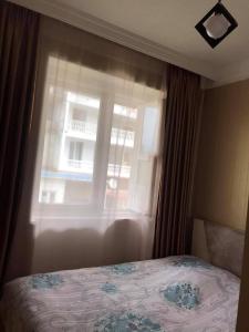 a bedroom with a bed in front of a window at Mariami's sweet home in Kobuleti