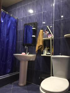 a blue tiled bathroom with a toilet and a sink at Mariami's sweet home in Kobuleti +11 photos