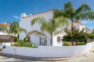 uma casa branca com palmeiras em frente em Villa Nova em Protaras