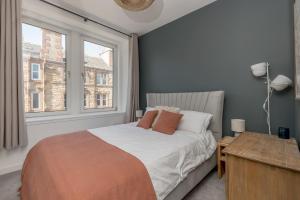 um quarto com uma cama e uma janela em Pass the Keys Stunning 3 Bed Loft Style Apt with Free Parking em Edimburgo