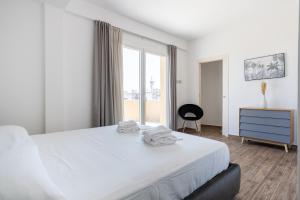 a white bedroom with a bed and a window at Solemar Sicilia - Multi Suite in Palermo