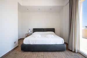 a bedroom with a bed with two towels on it at Solemar Sicilia - Multi Suite in Palermo
