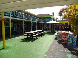 a patio with picnic tables in a building at Backpackers In Paradise Under 45's Hostel in Gold Coast
