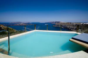 una piscina azul con vistas al agua en Suites of the Gods Cave Spa Hotel, en Megalokori