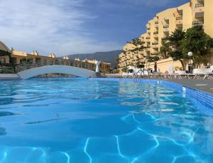 una gran piscina con un puente y edificios en Laguna Park 1, en Adeje