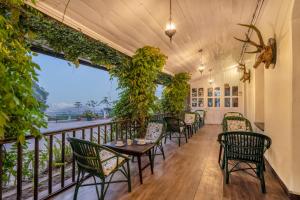 a row of chairs and tables on a balcony at Sterling Park Kalimpong in Kalimpong