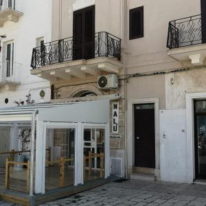 a building with glass doors and a balcony at Dimora Trinity in Polignano a Mare