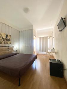 a bedroom with a large bed and a table at Green Gallery Hotel and Restaurant in Muravera