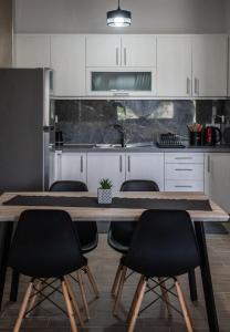a kitchen with a wooden table and chairs at Pandwra apartment in Chaïdeftón