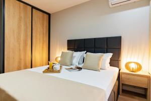 a bedroom with a large white bed with a black headboard at Burgas Beach Resort 2 Apartments in Burgas City +64 photos