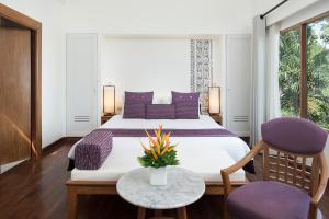 卡隆沙灘的住宿－Centara Villas Phuket - SHA Plus，一间卧室配有一张带紫色枕头的大床
